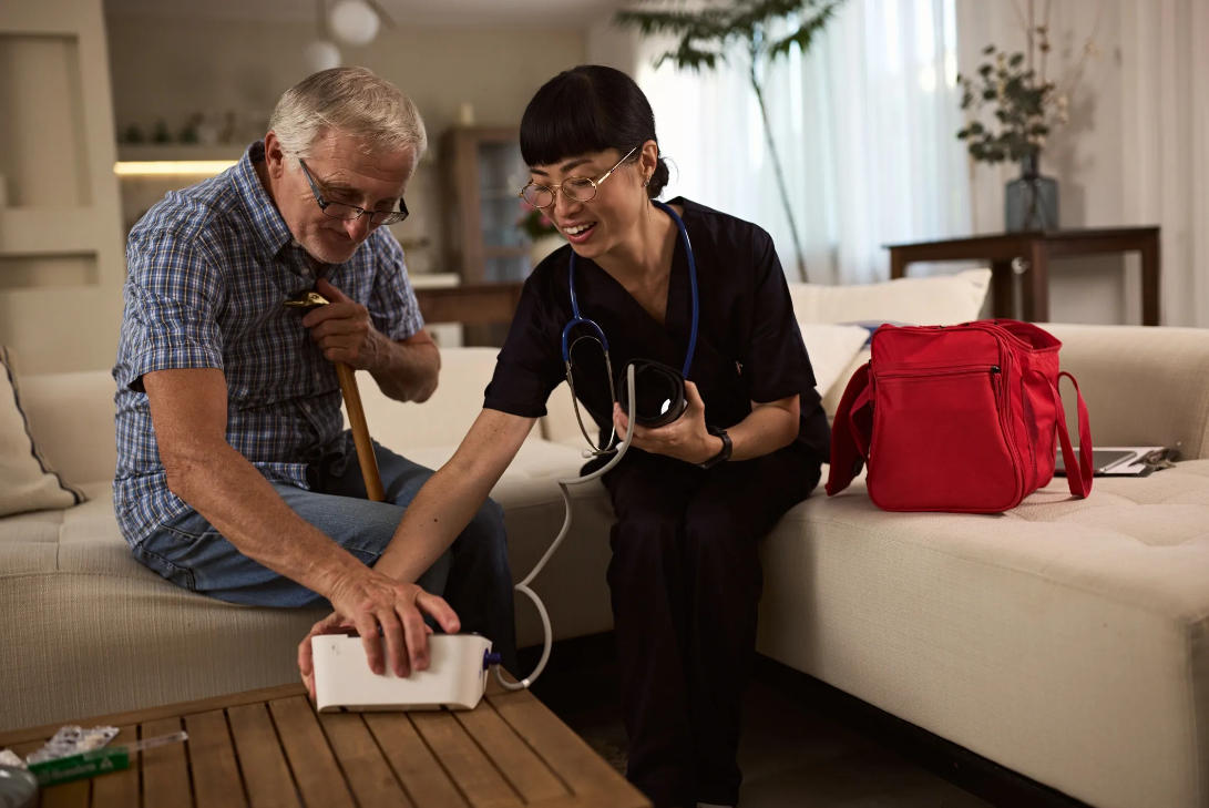 Licensed nurse checking an elderly patient's blood pressure during a home care visit
